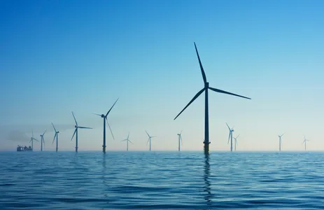 A white wind turbine against the sky